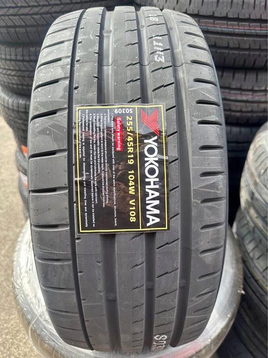 Yokohama tire with tread pattern and label in a stack of tires.