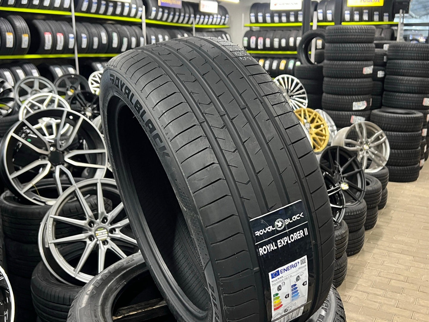 Tire with 'Royal Black' branding in a tire store setting