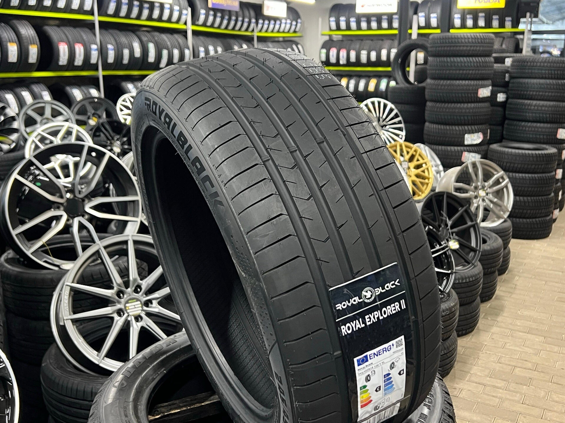 Tire with 'Royal Black' branding in a tire store setting