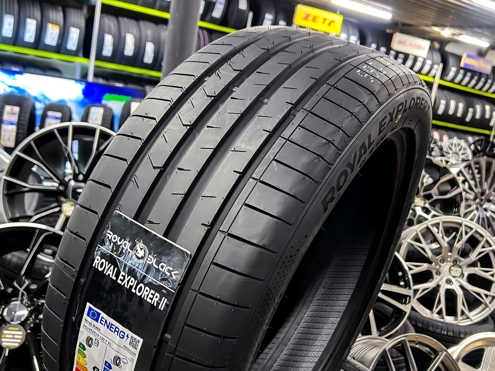 Car tire with 'Royal Explorer' branding in a tire store setting