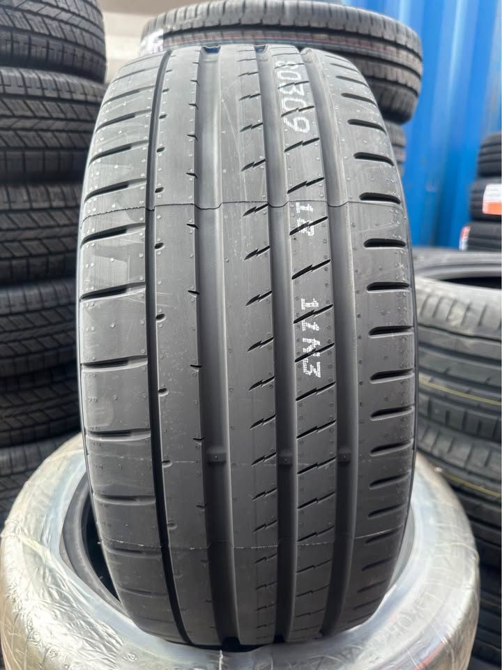Close-up of a  Yokohama EV tire with tread pattern and size details, surrounded by other tires.