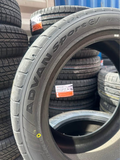 Stack of tires with a focus on an Advan Sport EV tire.